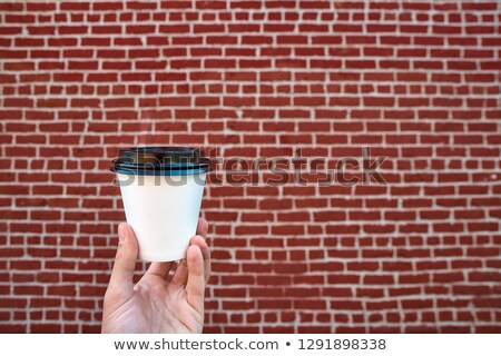 Stockfoto: Close Up Of Woman With Red Mug Against White Brick Wall