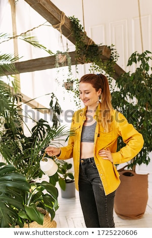 Stockfoto: Young Woman Watering Plants In Her Garden