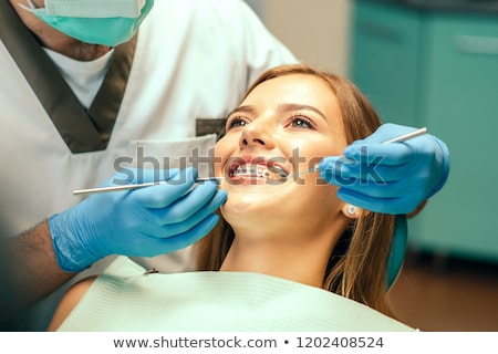 ストックフォト: Dentist Examining A Female Patient With Tools