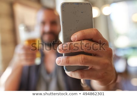 Сток-фото: Close Up Of Man With Smartphone And Beer At Pub