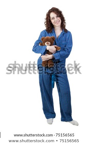 Stock photo: A Beautiful Young Woman Wearing Pajamas Hugging Her Stuffed Teddy Bear