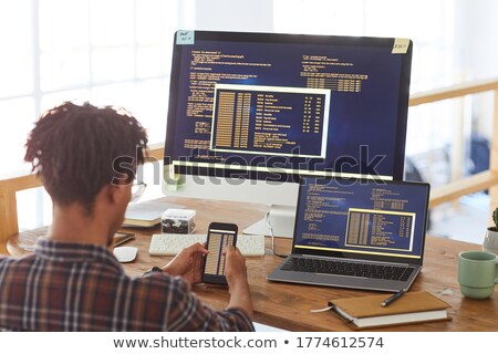 Stock fotó: Young Business Man Writes On The Back While At Laptop