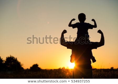 ストックフォト: Father And Son Walking On The Field At The Sunset Time