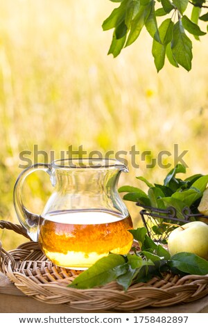 Stok fotoğraf: Apples In Basket And Jug Of Vinegar On Table