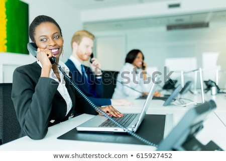 商業照片: A Beautiful Black Young Woman Working At A Call Center In An O