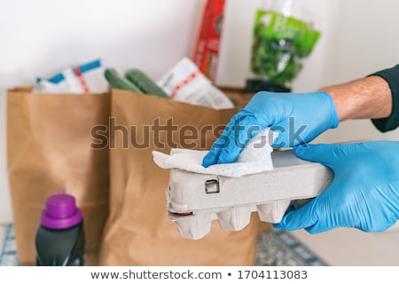 Cleaning Groceries Man At Home Wiping Egg Package With Sanitizing Wipes At Home After Shopping Or Re Zdjęcia stock © Maridav