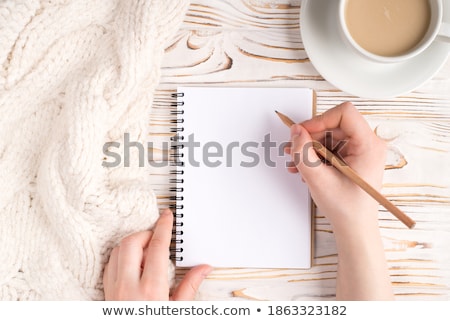 Сток-фото: The Girls Hands On A Table Near A Cup Of Coffee And A Notepad