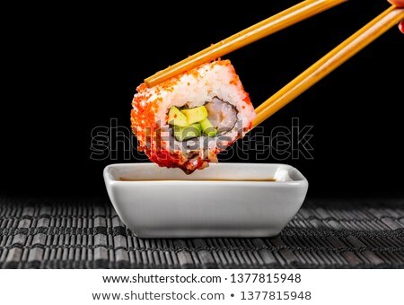 Stock foto: Sushi Roll Dipped In Soy Sauce