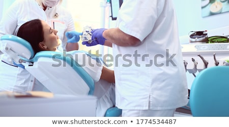 [[stock_photo]]: Dentists Working With Young Ethnic Girl In Chair