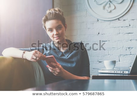 Stok fotoğraf: Businesswoman Looking At Camera While Holding Smartphone