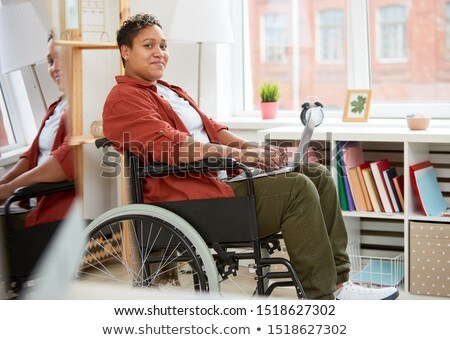 Imagine de stoc: Portrait Of Woman Sitting On Wheelchair Using Laptop