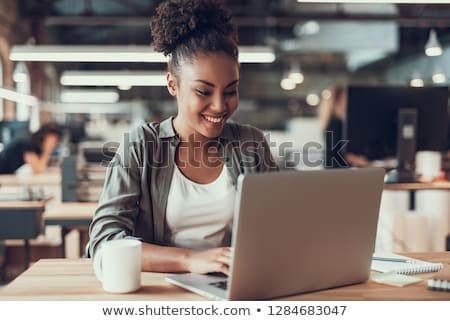 Stock fotó: Young Girl Sitting At Desk In Office Looking At Monitor And Waving Keyboard