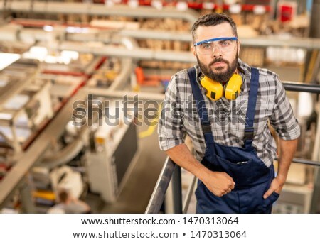 Serious Technician Of Large Factory In Protective Eyeglasses And Headphones 商業照片 © Pressmaster