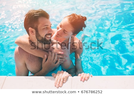 Stockfoto: Cheerful Youthful Guy And Lady Resting By Swimming Pool In Spa