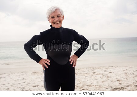 Foto stock: Front View Happy Senior Female Surfer Standing With Hands On Hip At Beach