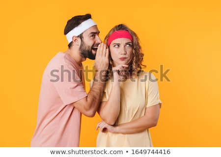 ストックフォト: Portrait Of Athletic Couple Wondering While Whispering Secret Or