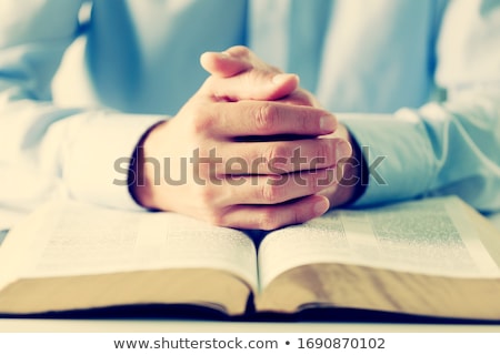 Foto d'archivio: Praying Hands On An Open Bible