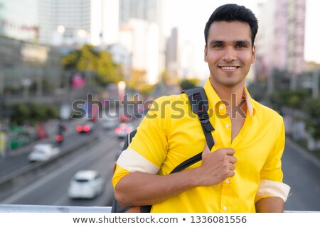 Stock photo: Young Smiling Man In Yellow Shirt On Footbridge