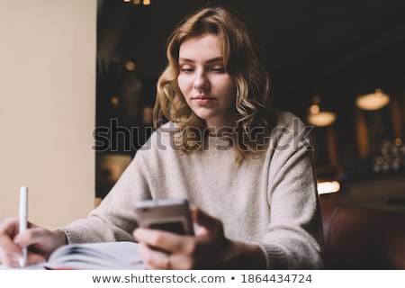 Stock fotó: Businesswoman Sitting In A Cafe And Writing In Organizer