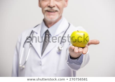 Stock foto: Portrait Of A Smiling Male Doctor Holding Green Apple On White