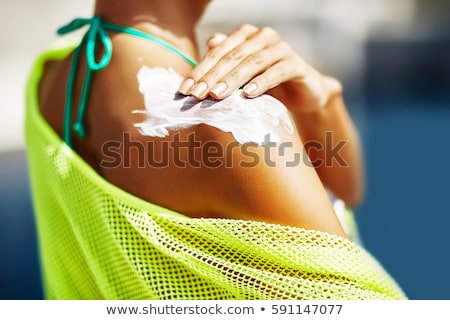 Foto stock: Young Woman Applying Sunscreen