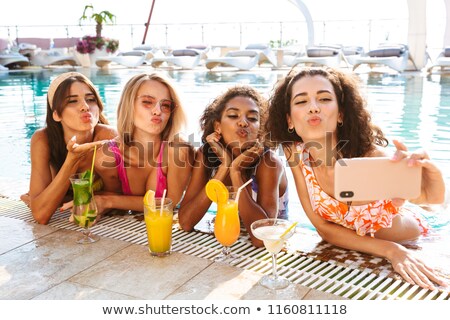 Stok fotoğraf: Four Cheerful Young Women In Swimwear Taking A Selfie