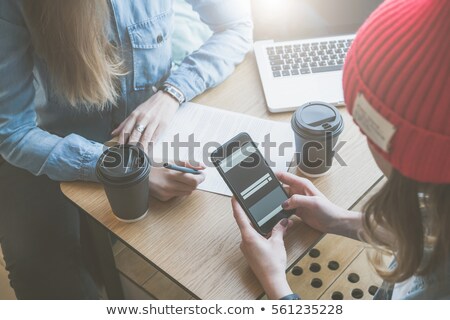 Сток-фото: A Young Girl Is Sitting At The Desk In The Office And Is Holding A Phone