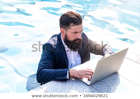 Foto stock: Young Freelancer Working On Vacation Next To The Swimming Pool