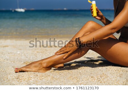 [[stock_photo]]: Woman Applying Sunscreen Lotion On Her Arm