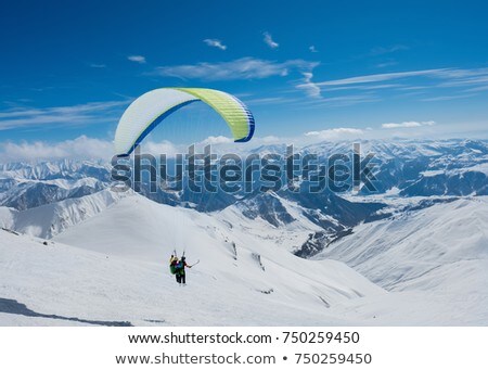 Zdjęcia stock: Paragliding Over The Mountains On Background Of Blue Sky And Whi