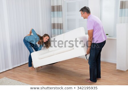 Сток-фото: Woman Suffering From Back Pain While Lifting Sofa