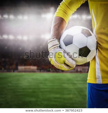 商業照片: Close Up Of Hand Holding Ball And Stadium In Background