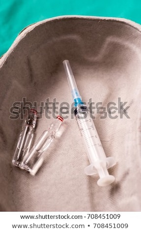 商業照片: Medical Syringe And Vials Lying In A One Use Capsule