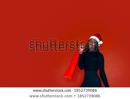 Foto stock: Hica · guapa · en · un · sombrero · rojo · de · Navidad · con · bolsas · de · colores · aislados · O