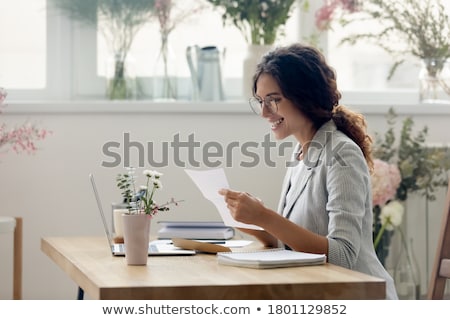 Stock photo: Smiling Businesswoman In Glasses Sitting On Chart