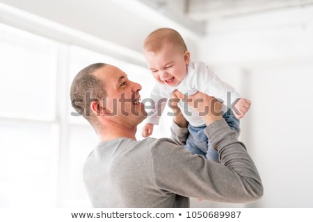 ストックフォト: Father Holds Baby On A Beautiful Room With White Windows