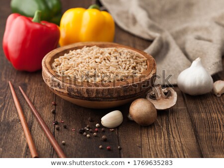 Zdjęcia stock: Wooden Bowl With Boiled Long Grain Risotto Rice With Mushrooms On Wooden Table Background With Stick