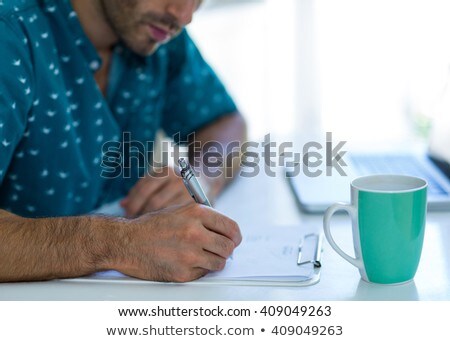 Сток-фото: Mid Section Of Man Writing On A Clipboard