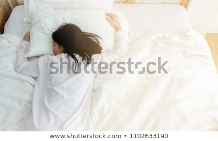 Foto stock: Young Sleeping Woman In Bedroom At Home Wearing In White