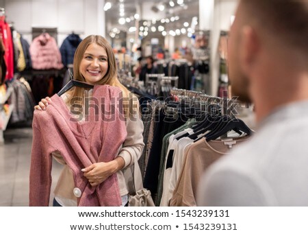 Stock fotó: Joyful Young Woman With Knitted Sweater By Chest Consulting With Her Boyfriend
