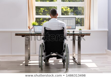 Сток-фото: Businessman Sitting On Wheelchair And Using Computer