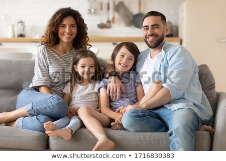 Foto stock: Family Of Four Embracing Sitting On The Kitchen Two Sons Hug Their Parents