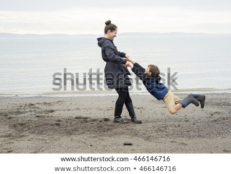 Boy Enjoying The Rain And Having Fun Outside On The Beach A Gray Rainy Foto d'archivio © Lopolo