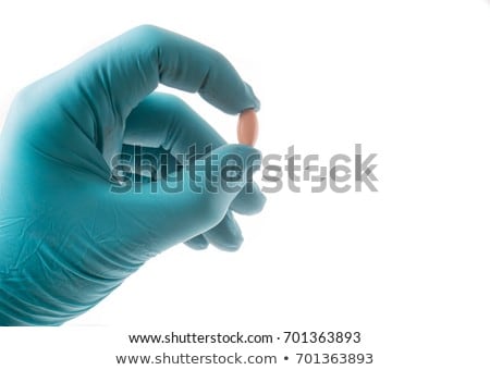 Stock fotó: Hand With Green Protective Glove Holding An Oblong Pill