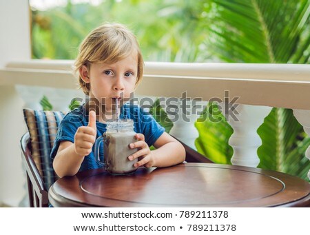 Stock photo: A Boy Drinks A Drink From A Carob