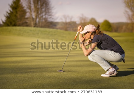 Сток-фото: Female Golf Player Squatting On Green