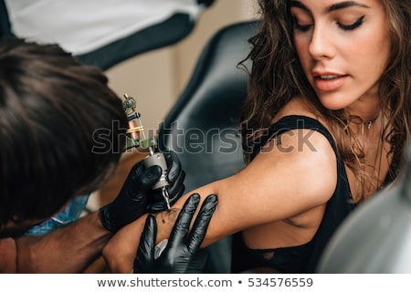 Stockfoto: People Getting Tattoo In Studio With Professional Tattooist Working