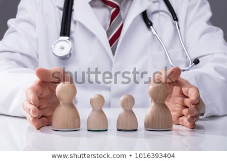 Stockfoto: Doctors Hand Protecting Wooden Pawn Family