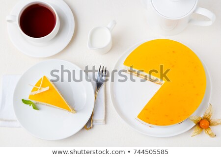 Stok fotoğraf: Passion Fruit Cake Mousse Dessert On A White Plate With Cup Of Tea Top View