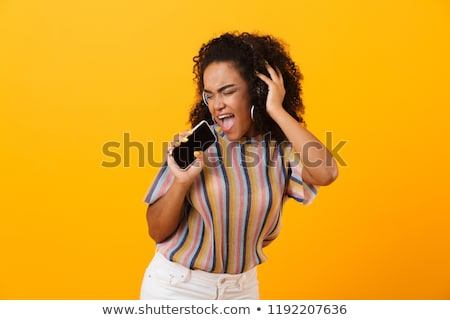 Zdjęcia stock: Woman Posing Isolated Over Yellow Background Listening Music With Headphones Dancing Singing